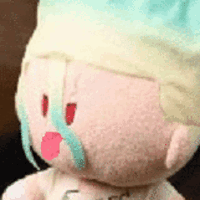 a close up of a stuffed animal with a hat on and a pink mouth .