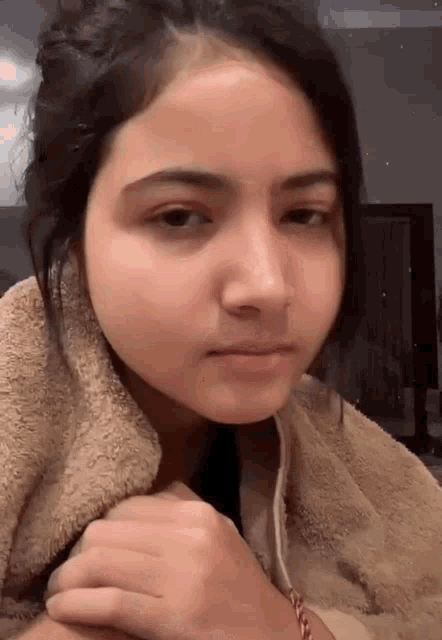 a close up of a woman 's face with a towel around her neck