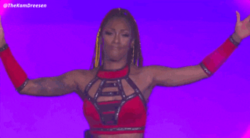 a woman in a red dress is standing in front of a pink background .