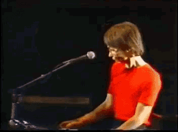 a close up of a person 's face with a red shirt on