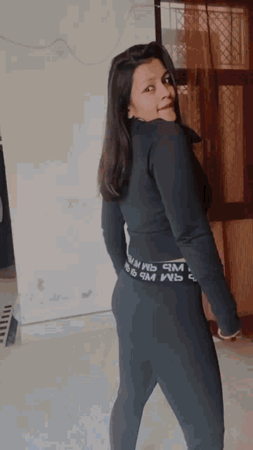 a woman wearing a black top and leggings with the word wb on the waistband