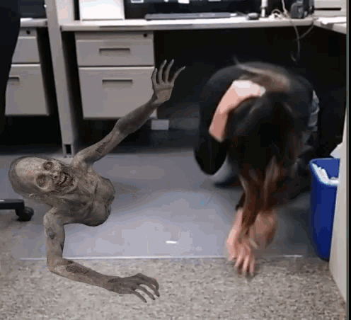 a woman is kneeling down in front of a zombie