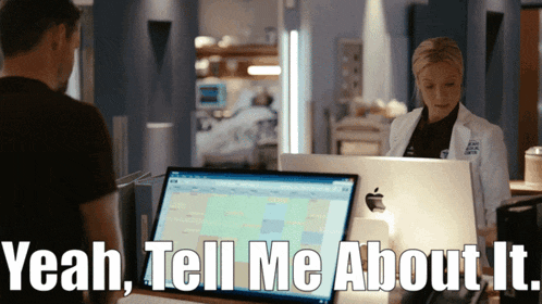 a man and a woman are standing in front of a laptop that says " yeah tell me about it "