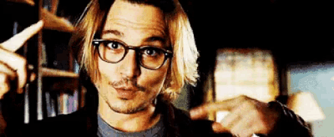 a man wearing glasses is pointing his finger at something .