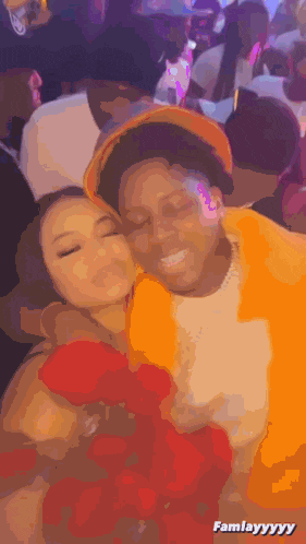 a man and a woman are hugging each other in a crowded room and the caption says famleyyyy