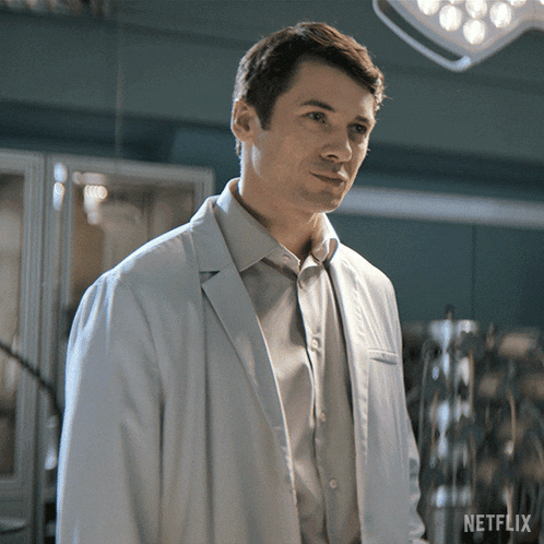 a man in a white lab coat stands in front of a netflix sign