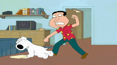 a man in a red shirt is standing next to a white dog in a living room