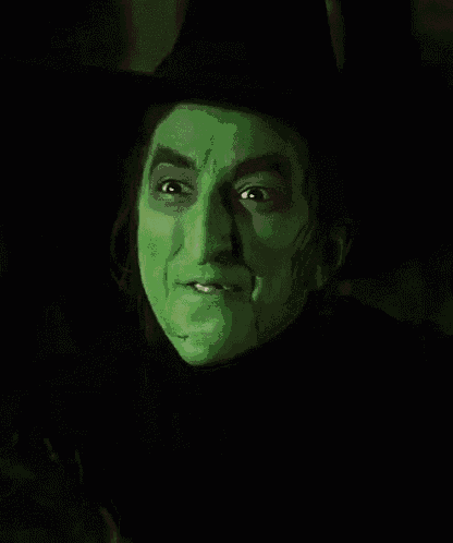 a close up of a witch 's face with green paint on it
