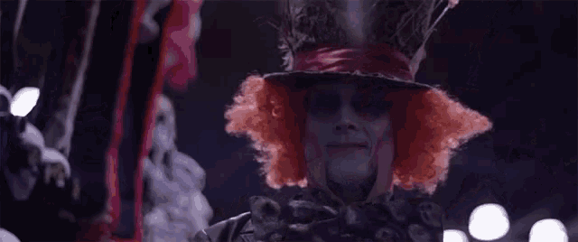 the mad hatter from alice in wonderland is wearing a red wig and hat .