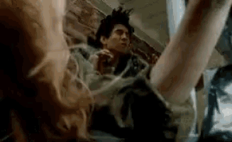 a man is being attacked by a monster in a movie while laying on the floor .
