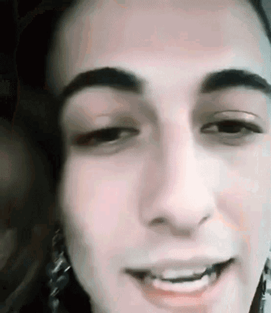 a close up of a woman 's face with her eyes closed and a smile on her face .