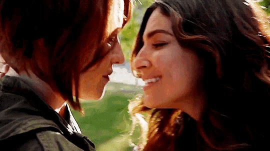 a close up of two women kissing each other on the nose .