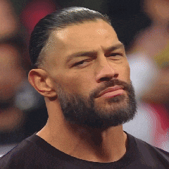 a man with a beard wearing a black shirt looks at the camera