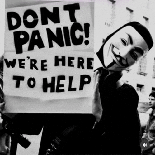 a man holding a sign that says " do n't panic "
