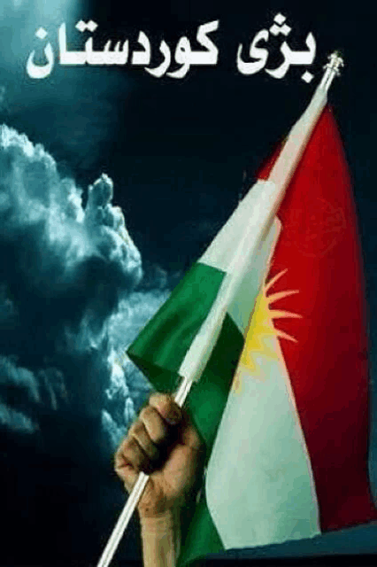 a hand is holding a kurdish flag in front of a cloudy sky