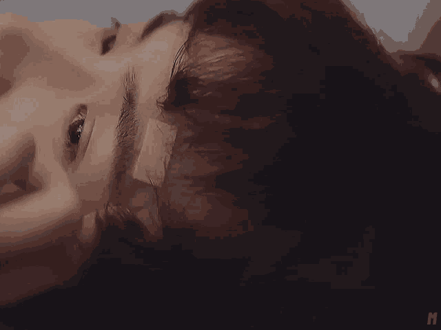 a close up of a woman laying down with a bandage on her face