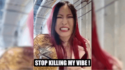 a woman with red hair is holding a championship belt and making a funny face .