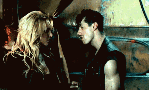 a man and a woman are standing next to each other in a dark room