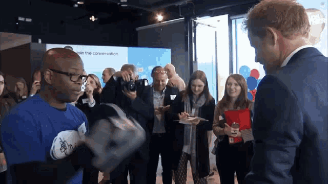 a man wearing a blue shirt that says " join the conversation "
