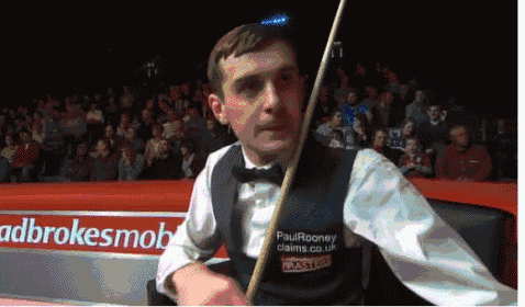 a man holding a snooker cue in front of an ad for adbrokersmobile