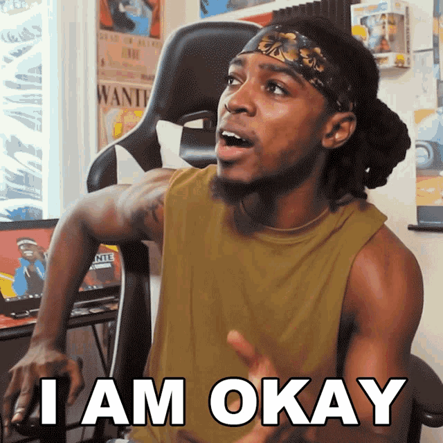 a man sitting in a chair with the words i am okay written on his chest