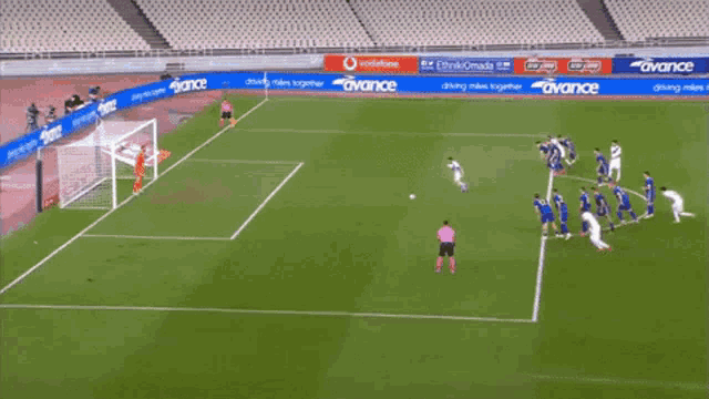 a soccer game is being played in a stadium with ads for vodafone and avance