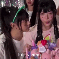 a group of girls are standing around a cake with the words luli y ainu written on the bottom