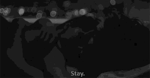 a black and white photo of a man and woman kissing with the words " stay " above them