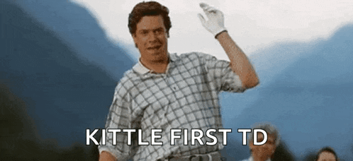 a man in a plaid shirt and white gloves is waving his hand and says `` kittle first td '' .