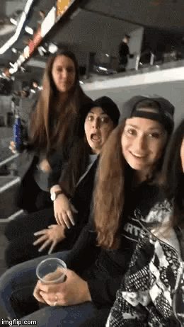 a group of young women are sitting in a stadium and one of them is wearing a shirt that says rt