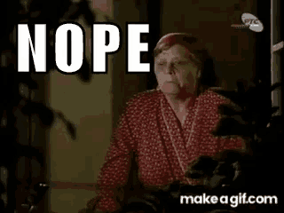 an elderly woman in a red robe is sitting in front of a sign that says nope