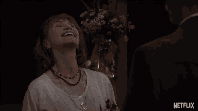 a woman is laughing with a netflix logo in the background