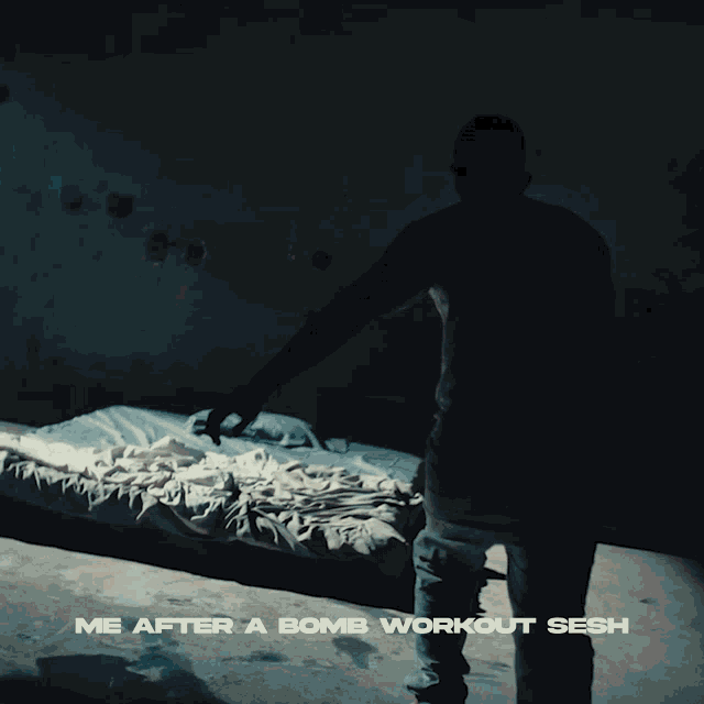 a man standing in front of a bed with the words me after a bomb workout sesh