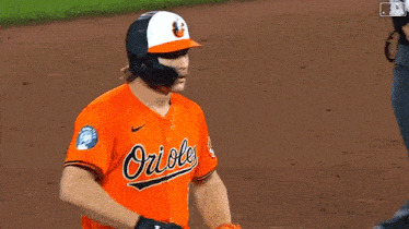 a baseball player wearing a helmet and an orioles jersey