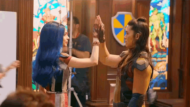 a man and a woman are giving each other a high five .
