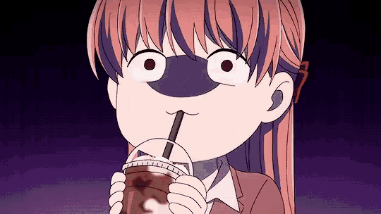 a girl is drinking from a cup with a straw and making a funny face .