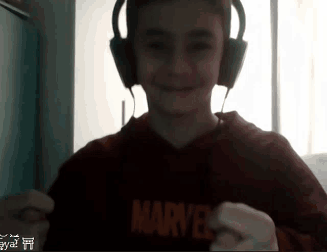 a young boy wearing headphones and a marvel hoodie