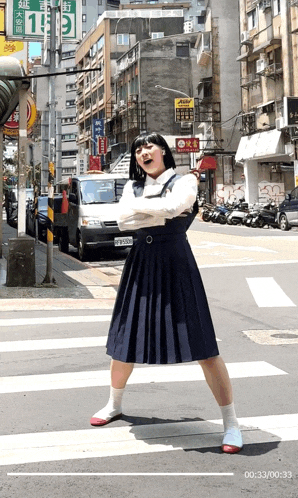 a woman in a school uniform is crossing a street in front of a sign that says ' 1 ' on it