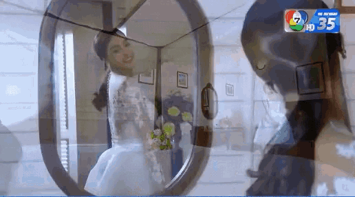 a woman in a wedding dress is standing in front of a mirror