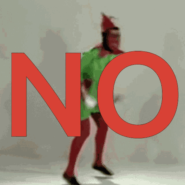 a man in a green shirt is standing in front of a red no sign