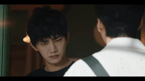 a man in a black shirt is looking at another man