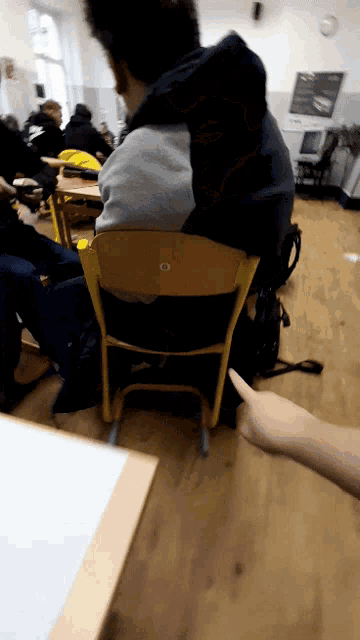 a man sits in a chair in a classroom