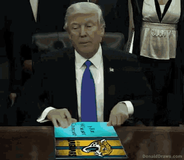 a man in a suit and tie is holding a book that says jacksonville jaguars
