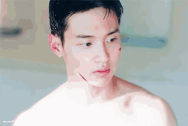 a man without a shirt has a wound on his face