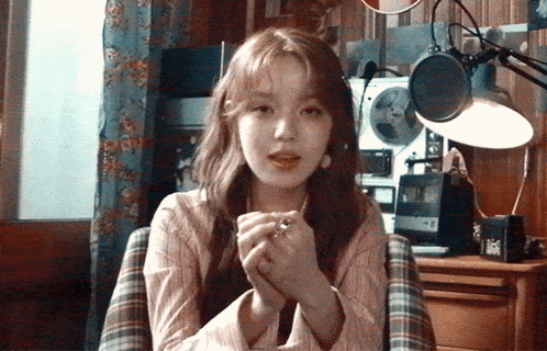a woman is sitting in front of a microphone and a record player