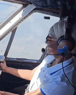 a man wearing headphones and a name tag that says ' i 'm a pilot '