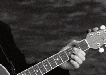 a black and white photo of a man playing a guitar