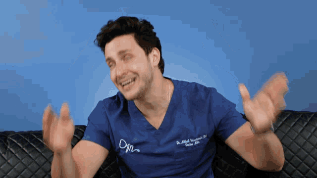 a man wearing a blue scrub top with the letters dm on the front