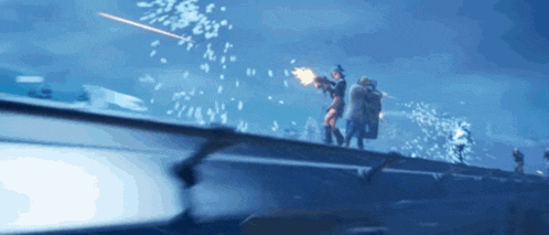 a group of people are standing on top of a bridge while a rocket is flying through the air .