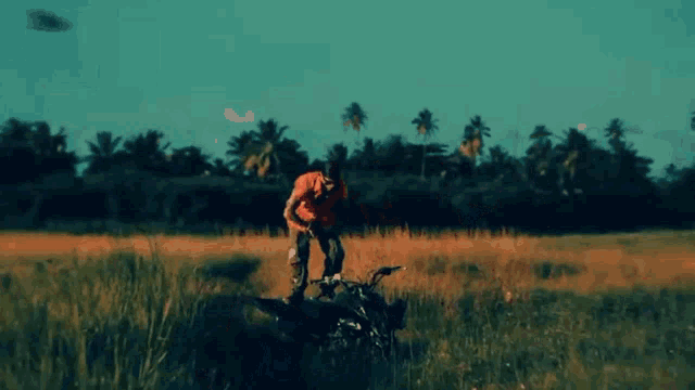 a man wearing sunglasses and a bandana is kneeling down